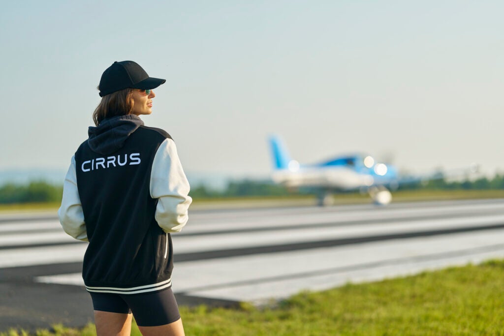 women wearing a Cirrus jacket next to a SR Series aircraft 