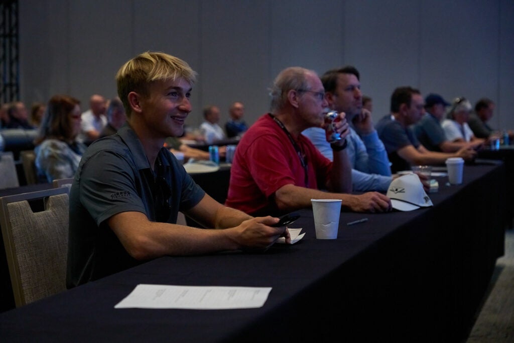 A young adult sitting in a presentation 