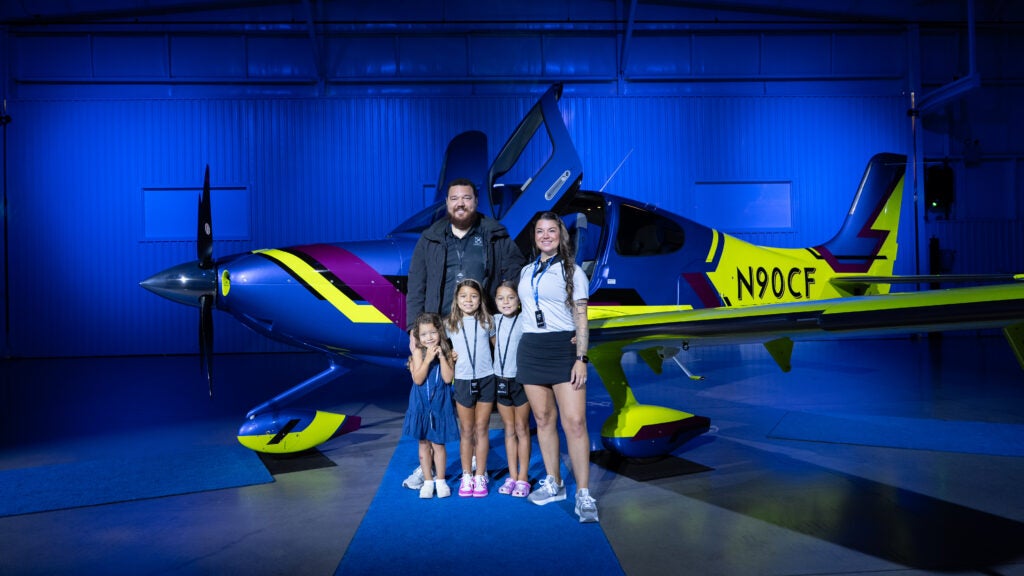 family in front of colorful Xi sr series plane