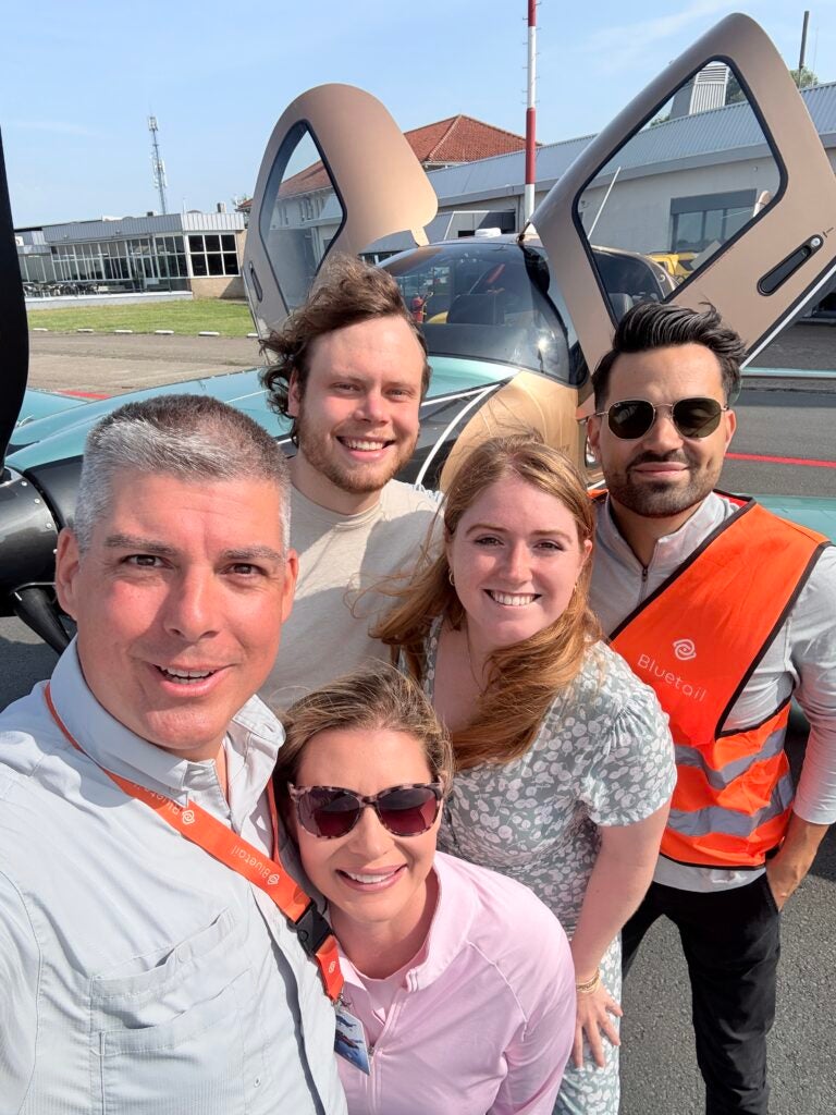 group picture in front of cirrus plane