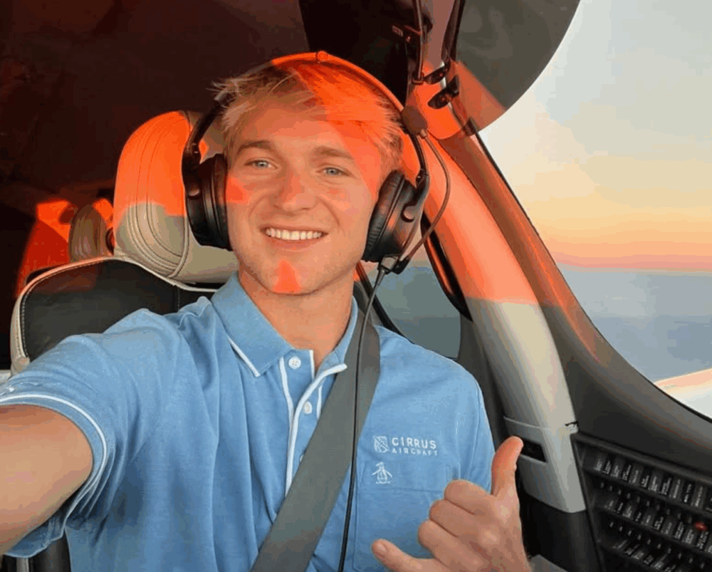 young adult flying a vision jet wearing a blue polo cirrus shirt