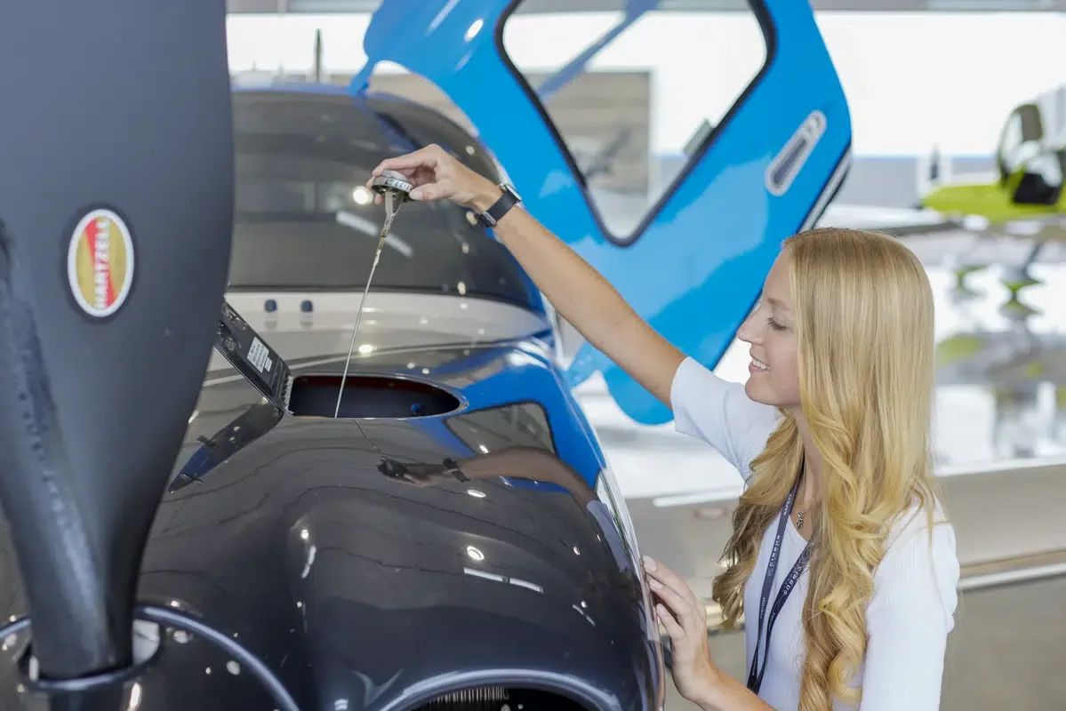 girl checking oil of plane